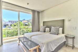 Enjoy city and mountain views from the comfort of this room, featuring two beds and a convenient bench.