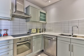 A modern kitchen with stainless steel appliances, a dishwasher, and a built-in oven.