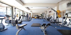 A gym with treadmills, weight machines, and exercise balls.