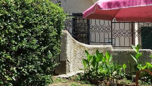 A courtyard with a table and chair, a potted plant, and a building with a balcony. - House, Villa - Polveraia, Scansano, Grosseto (Scansano)