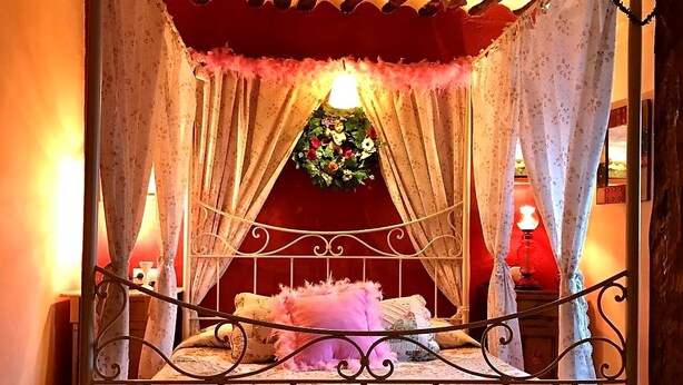 A four-poster canopy bed with floral bedding and a red headboard. - Room-getaway to Cuenca at La Quinta de M (Las Valeras)