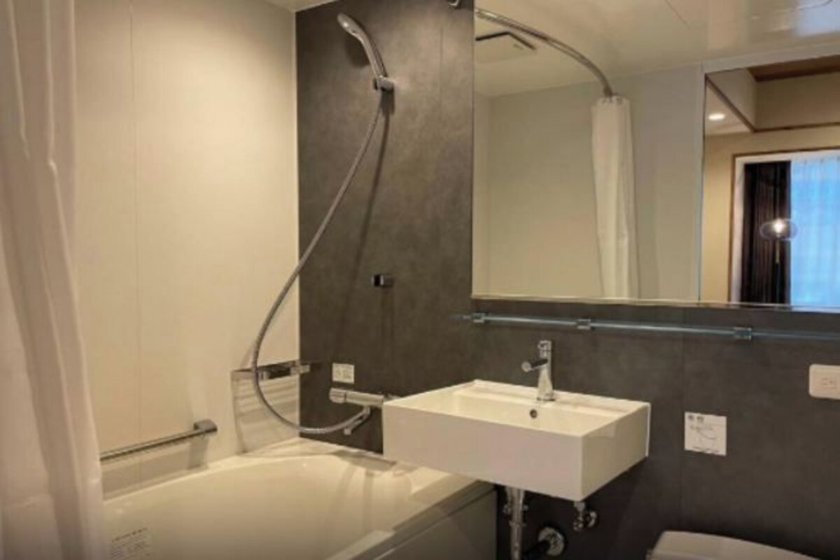 A modern bathroom with a bathtub, a sink, and a shower.
