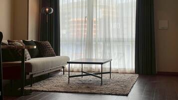 A living room with a sofa, a coffee table, and a rug.
