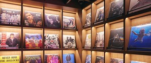 A wall of vinyl records displayed in a wooden shelving unit. - BAND HOTEL HAKATA (Fukuoka)