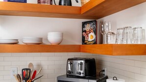 Una cocina con una tostadora, un microondas y un libro titulado "Big Bad Breakfast" de John Currence.