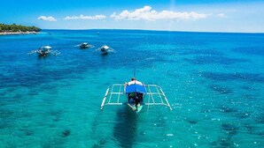 Une mer d’un bleu profond où navigue un bateau transportant des passagers.
