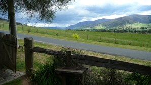 A rural road with a wooden fence and a bench.