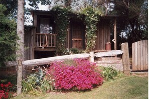 A rustic wooden cabin with a wooden deck and a small porch.