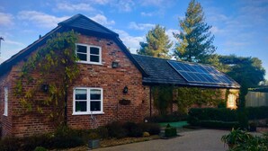 A brick house with a sloped roof and solar panels. - Luxury Accom With Pool Henbury Macclesfield (Macclesfield)