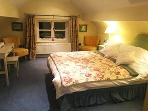 A bedroom with a bed, a desk, and a chair.