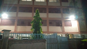 Un bâtiment doté de nombreuses fenêtres, avec un arbre devant.