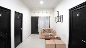 A modern living room with a sofa, a coffee table, and a door labeled '01'. - Dparagon Pamela 4 (Depok)