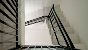 A staircase with white walls and black railings, leading upwards. - Dparagon Pamela 4 (Depok)