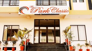 La entrada de The Park Classic, una unidad de Classic Heights Hotels, con una escalera que conduce a la entrada, flanqueada por macetas con plantas.