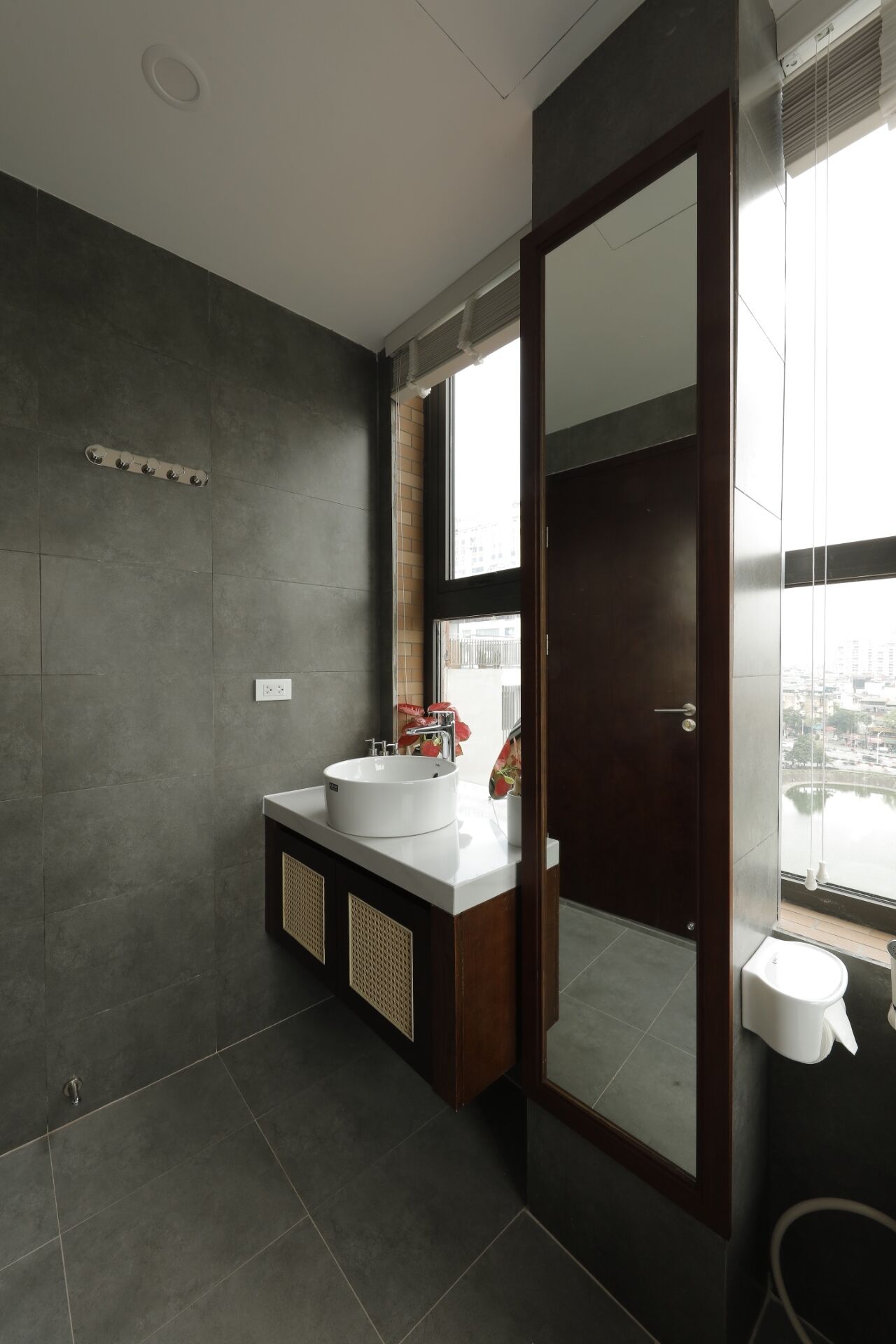 Een moderne badkamer met een grote spiegel, een witte wastafel en een toilet.