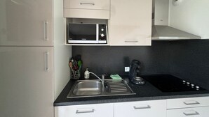 Une cuisine moderne équipée d’un four à micro-ondes, d’un évier et d’une cuisinière.