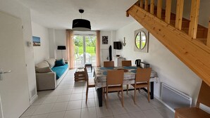 Un vaste espace de vie comprenant une table et des chaises, un canapé et un escalier.