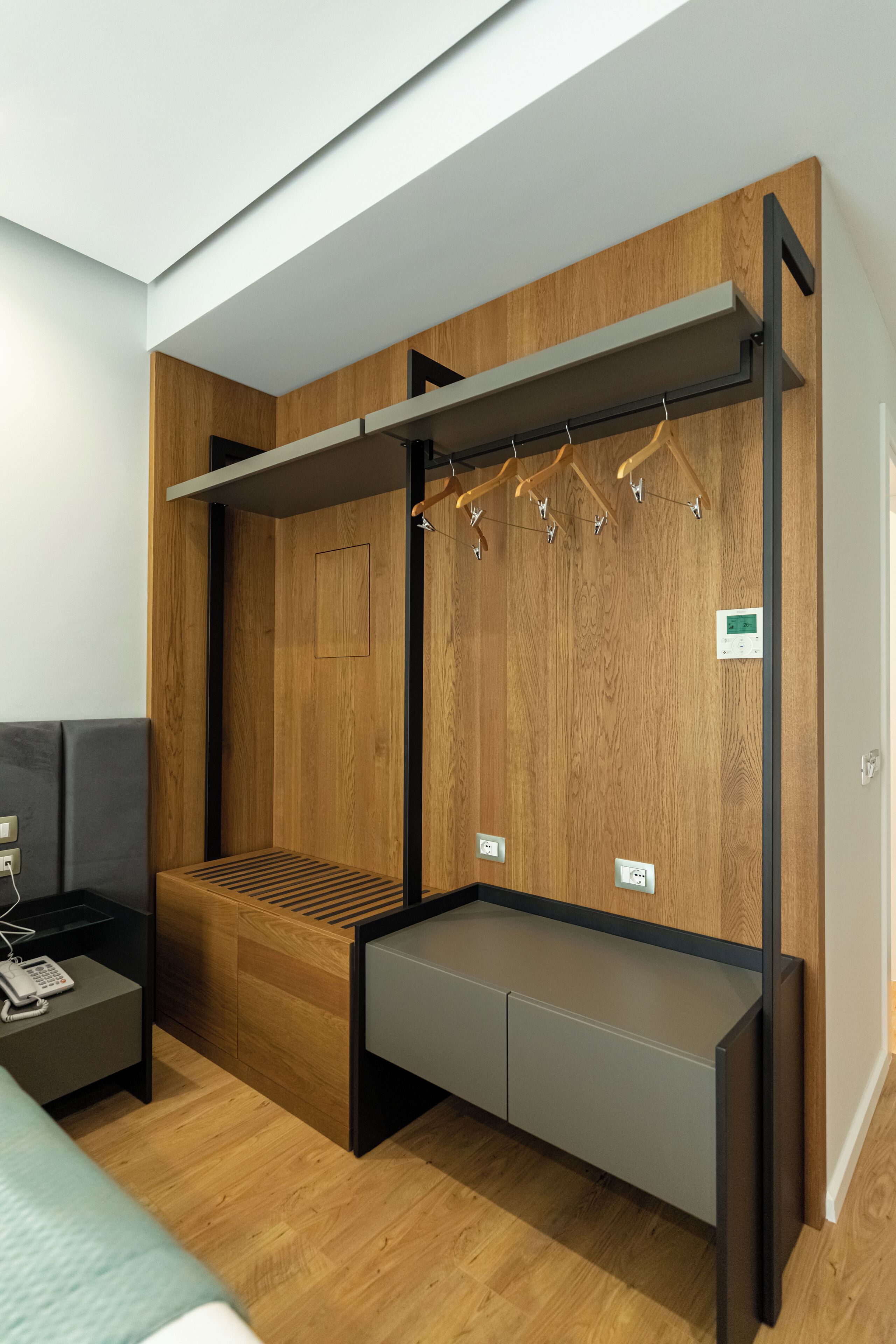Une chambre moderne équipée d’un lit, d’un bureau et d’une armoire intégrée avec des finitions en bois.