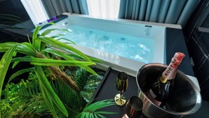 A spa tub with a bottle of champagne and glasses.