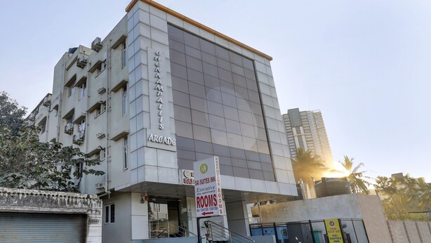 Un immeuble à plusieurs étages, sur lequel on peut lire l’inscription « SAI SUITES INN », indiquant la présence de chambres de catégorie supérieure.