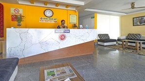 Un espace d’accueil avec un comptoir en marbre, une horloge et un panneau indiquant « Il est interdit de fumer ».