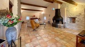 Ein geräumiges Wohnzimmer mit Kamin, einer Couch und einem Couchtisch.