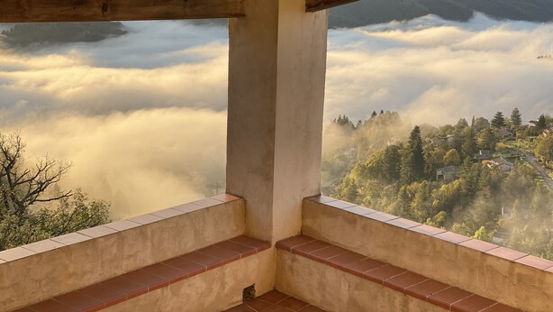 Ein Holzbalkon mit Blick auf eine gebirgige Landschaft und ein Tal.