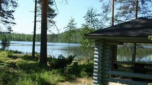 A cabin with a view of a lake surrounded by trees. - Taulun Kartano (Toivakka)