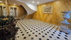 A lobby with a checkered floor, a staircase, and a decorative wall. - Invalides•Tour Eiffel | Charming flat Paris Centre (Paris)