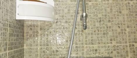 A shower with a handheld showerhead and a wall-mounted faucet.