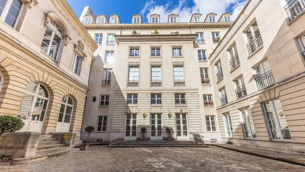 A historic building with a central courtyard, large windows, and a symmetrical facade. - Chic Designer Loft in Historic Mansion • Marais (Paris)