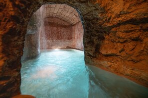 A stone-lined tunnel with a pool at the end. - Camera Paradiso - Racale (Racale)