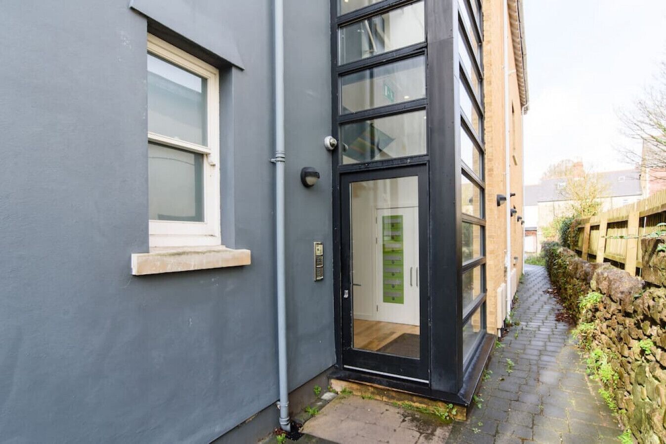 Un bâtiment moderne doté d’une grande porte vitrée et d’une petite fenêtre.