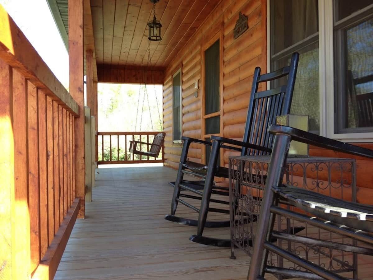 A wooden cabin with a porch, rocking chairs, and a hanging lantern.