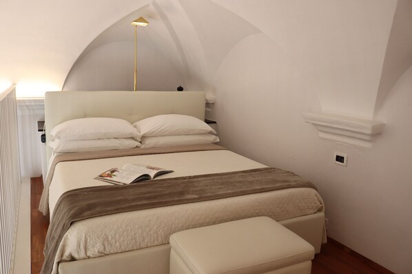 A bedroom with a large bed, a bedside table, a lamp, and a window. - kaDevi Holiday home -full center, private garage and bikes (Sanremo)