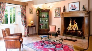 Un salon chaleureux avec une cheminée, un meuble en bois et un fauteuil confortable.