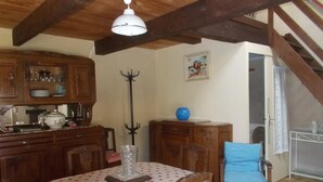 Un comedor con una mesa de madera, sillas y un ventilador de techo.
