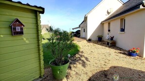 A narrow alleyway with a green building on the left and a white building on the right, both with small windows and doors. - Ker Mignonette - Trevou Treguignec (TREVOU TREGUIGNEC)