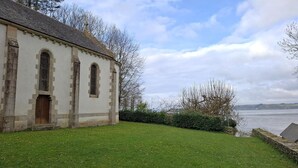 A historic building with a stone facade, arched windows, and a wooden door. - Le Jardin - Plestin LES Greves (PLESTIN LES GREVES)