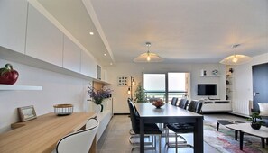 A modern living space with a dining area, kitchen, and seating area.