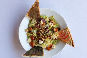 A plate with a salad, croutons, and a piece of toast. - Outpost Ubud Coliving Suites (Ubud)
