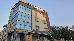 A multi-story hotel with a modern facade, featuring large windows on the ground floor and balconies on the upper floors. - Treebo Trend Hotel Sampradaya (Bengaluru)
