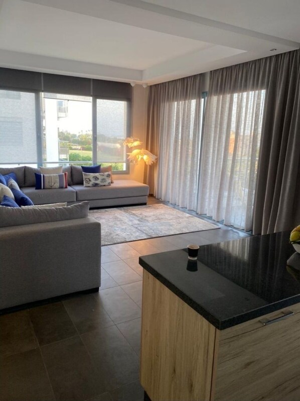 Relax in this stylish living room with a large sofa, coffee table, and cabinet.