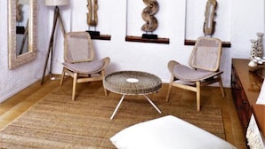 A room with a chandelier, two chairs, a round table, a mirror, and wall-mounted decor. - Sea View Luxury Villa (Siviri)