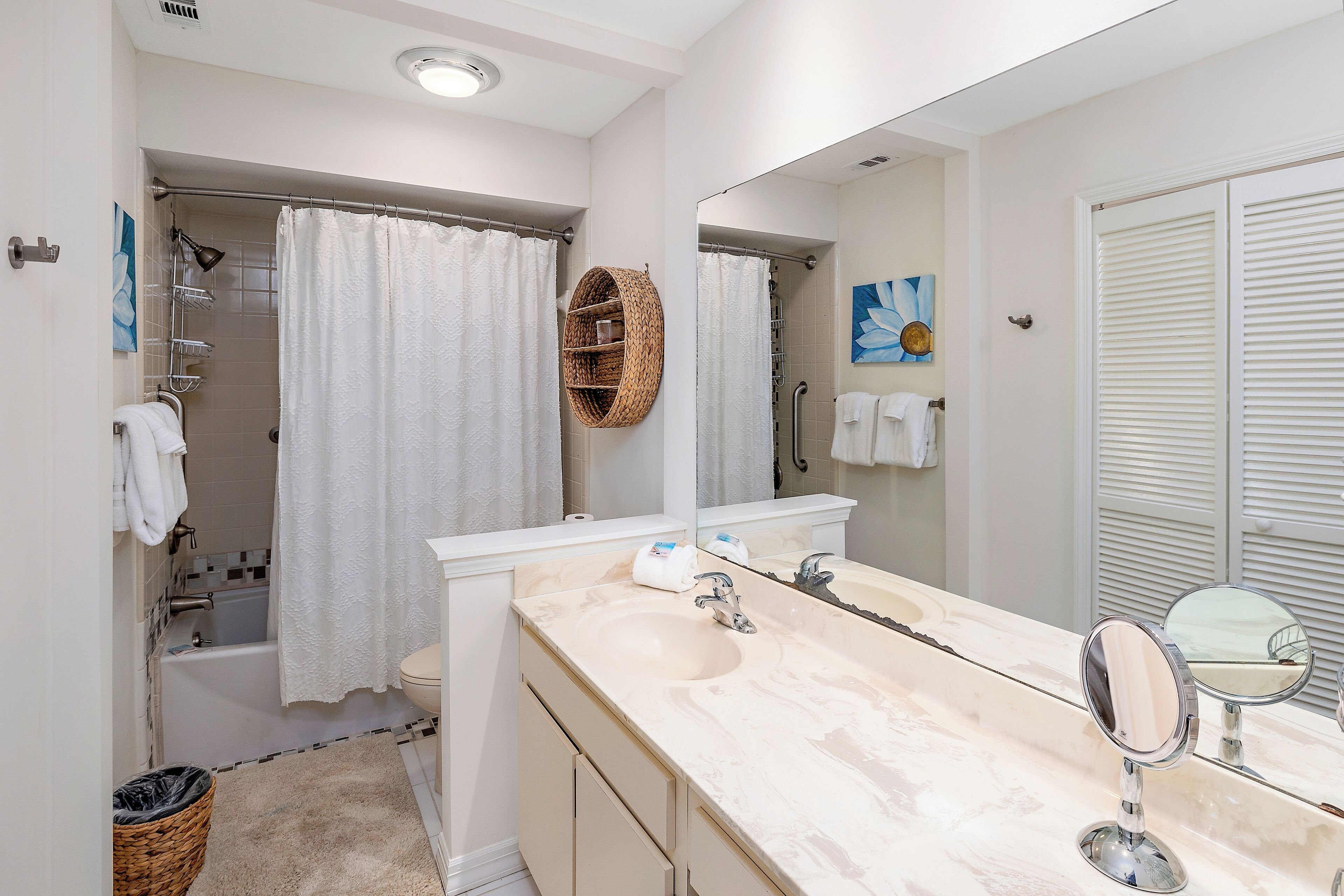 Un baño moderno con bañera, un espejo grande y un lavabo con pileta.