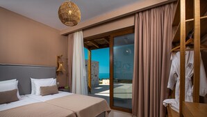 A hotel room with a bed, a wardrobe, a bathroom, and a view of the sea. - Terra Lucis Mountain Residences/ Mare Villa (Zakynthos)