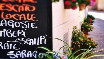 A blackboard with a list of food items written in white chalk.