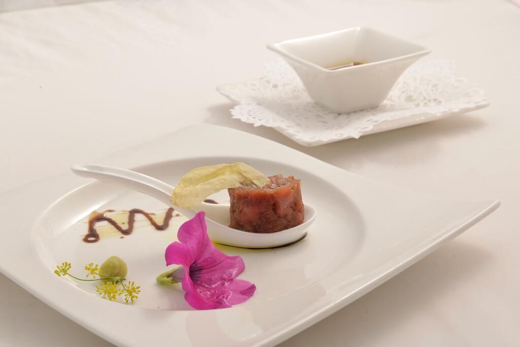 A white plate with a dessert, a small bowl, and a lace doily.