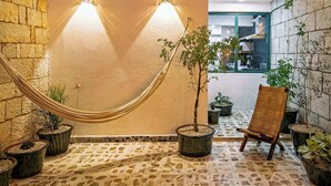 A multi-level interior with a hammock, potted plants, and a wooden chair. - HOLT's Villa Noria, La Casa del Barro Verde (Oaxaca de Juárez)