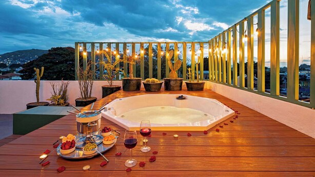 A rooftop terrace with a hot tub, potted plants, and a dining setup with food and drinks. - HOLT's Villa Noria, La Casa del Barro Verde (Oaxaca de Juárez)